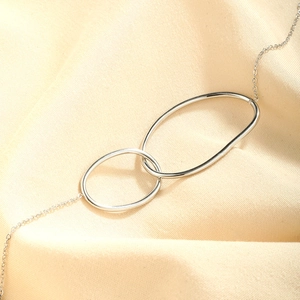 Minimalist silver stainless steel double interlocking oval ring bracelet on silk fabric