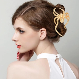Detailed close-up of a large golden metal spider hair claw clip on a model's hair