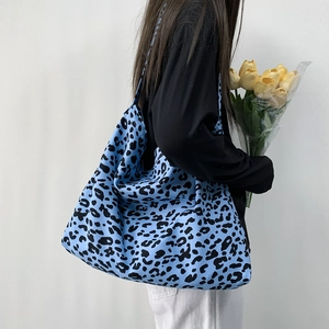 Blue leopard print corduroy tote bag worn by model, showing large capacity and vibrant style