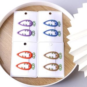 Close-up of matte carrot-shaped hair clips in candy colors on white display cards