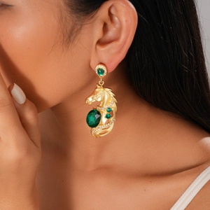 Close-up of vintage gold horse head earrings with green stones and sparkling rhinestones