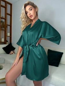 Détail du peignoir en satin vert foncé avec texture soyeuse et ceinture nouée