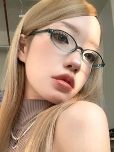 Retro translucent green oval glasses frame worn by a model in a close-up portrait