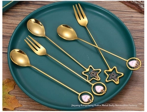 Detailed macro of golden stainless steel dessert fork with pink love heart pendant