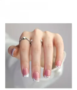 Detail of short square press-on nails with white French wave patterns and pink base