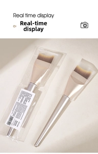 Macro detail of crescent foundation brush with soft synthetic bristles and champagne gold handle