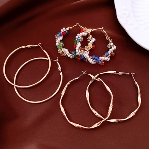 Flat lay of gold hoop earring set with hammered textures and colorful crystal beads