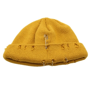 Berretto in maglia giallo senape con anelli metallici, spilla e dettagli strappati