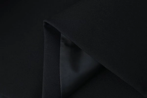 Close-up of black blazer fabric showing high-quality twill texture and durable weave detail