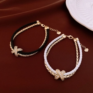 Close-up of double-layer braided bracelets with gold X-link and heart Love charm