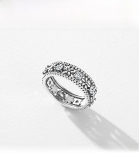 Macro detail of S925 silver daisy ring featuring pavé diamonds and floral relief