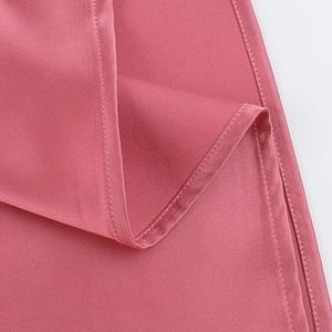 Close-up of pink satin dress showing premium fabric texture and neat stitching details