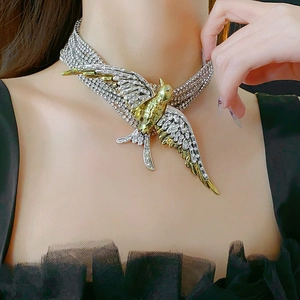 Close-up of multilayer bird necklace featuring gold and silver tones with sparkling crystals
