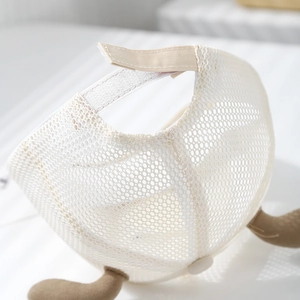 Detail of white mesh baby cap showing breathable texture and adjustable Velcro strap back