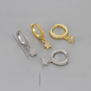 Detail view of star drop earrings in platinum and golden finish with zircon inlays