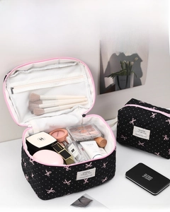Detail of white polka dot bow cosmetic bag interior with mesh pocket and dual zippers