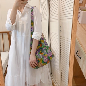 Detail of colorful abstract floral print cotton tote bag worn with casual white dress