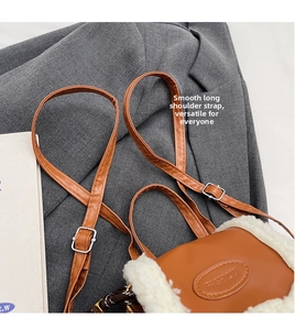 Detail of brown faux leather shoulder bag with white plush trim and adjustable strap