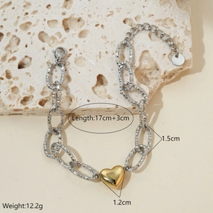 Detail of hammer-textured links and golden heart charm on bicolor stainless steel bracelet