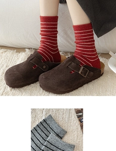 Detail of wool mid-calf socks with contrast stripes in red and grey knitted texture