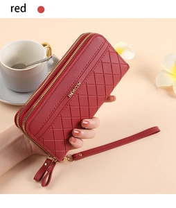 Macro shot of red long wallet with diamond quilting, gold zippers and wristlet strap