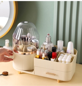 Detail showing segmented cream makeup organizer with brush holder and gold handle drawer