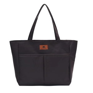 Minimalist black nylon tote bag with front pockets and slim shoulder straps for daily commute