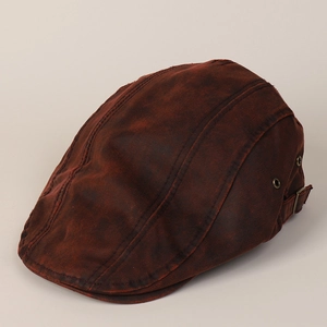 Detailed view of vintage distressed beret with side vent and adjustable metal buckle