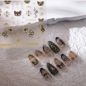3D embossed gold Egyptian nail stickers with Anubis and Horus eye on olive nails