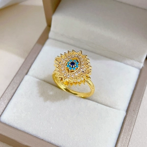 Evil eye spinning gold ring with blue stones and zircons in a jewelry box