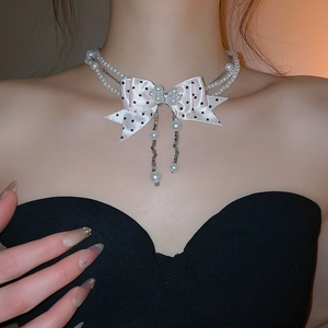 Detail of pink polka dot bow pearl choker with rhinestone cluster and tassel