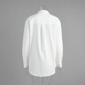 Detail view of the pleated back design on a white cotton linen shirt dress