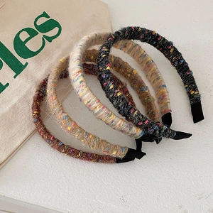 Detail of four colorful knitted plaid headbands in brown, beige and black