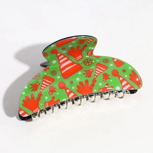 Detail of green semi-circle hair claw clip with festive Santa Claus and snowflake prints