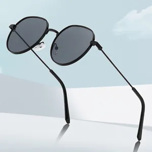 Classic retro sunglasses with black metal frame and dark lenses on reflective surface