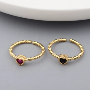 Detail of red and black heart-shaped gemstone rings with 18k gold-plated bands
