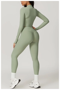 Detail of high-waist yoga leggings with heart-shaped seams and sage green athletic top