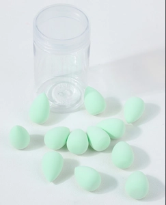 Set of 12 mint green mini teardrop makeup sponges with a clear storage container