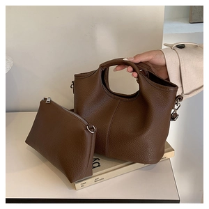 Close-up of brown litchi pattern leather bucket bag set with silver hardware details
