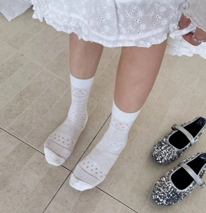 Detailed close-up of white hollow floral pattern on breathable mid-calf crew socks