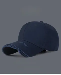 Detail shot of distressed brim edges on a navy blue twill cotton baseball cap