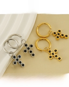 Detailed macro view of 18k gold and silver stainless steel cross hoop earrings