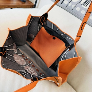Interior view showing the orange knitted tote bag with a matching inner storage pouch