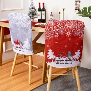 Festive Christmas gnome chair covers in red and grey shown on dining chairs in a cozy setting