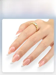 Macro shot of pink french almond press-on nails with white tips and gold ring detail