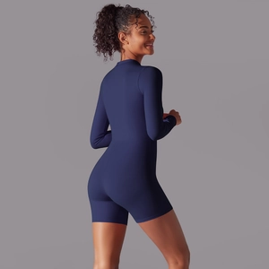 Rear view of sleek dark blue long sleeve yoga romper showing fitted cut and premium fabric