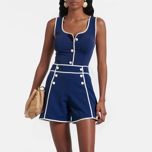 Detail of navy blue one-piece swimsuit with white contrast piping and decorative buttons