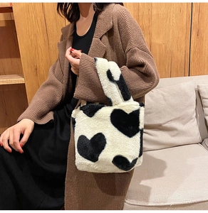 Detailed view of the soft plush heart-patterned texture on the black and white handbag