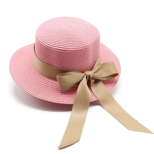 Dettaglio cappello di paglia rosa con nastro beige e grande fiocco laterale elegante