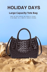 Close-up of brown woven leather tote bag with handles on a sandy beach setting